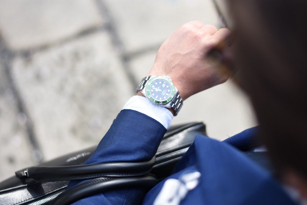 Photo of well-dressed person with watch, briefcase and sunglasses.